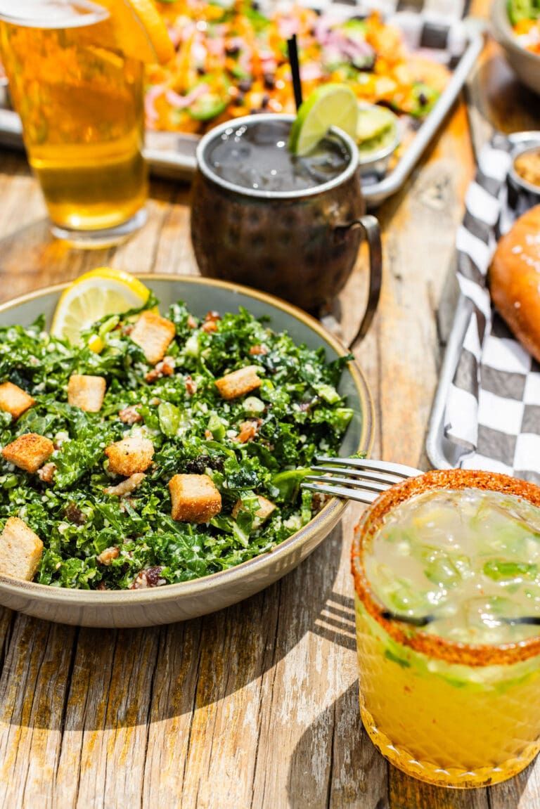 Craft cocktails and beer alongside a fresh salad on the floor at Lucy's